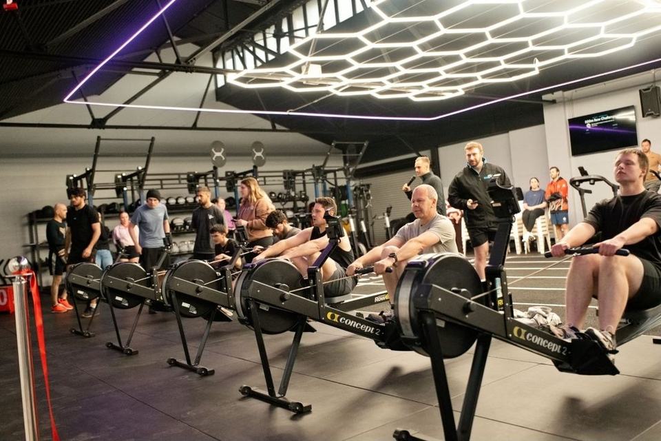 Members racing on rowers at a Cave Gym event
